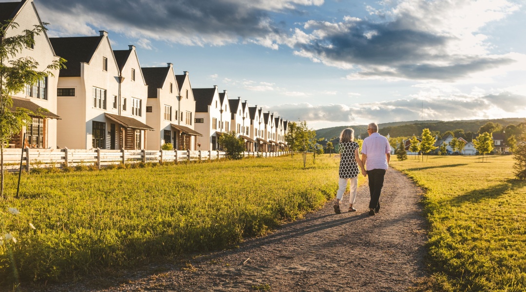 Couple walking in front of white houses